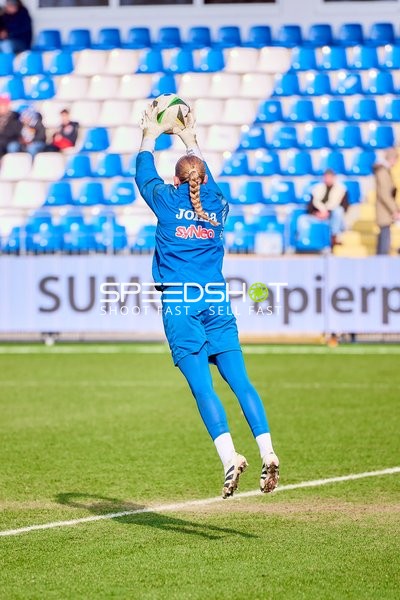 Eine Person in blauer Kleidung fängt den Ball während des Spiels.