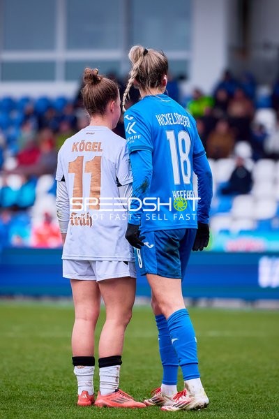 Spielerinnen stehen nah beieinander auf dem Spielfeld.