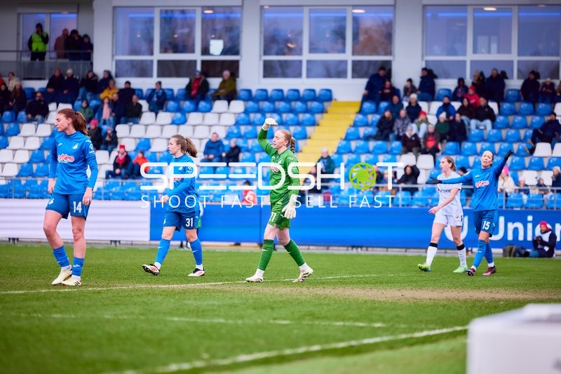 Spielerinnen von TSG Hoffenheim und Bayer Leverkusen bewegen sich auf dem Spielfeld, eine TSG-Spielerin hebt die Hand.