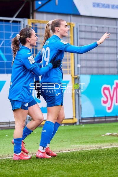 Zwei Spielerinnen von TSG Hoffenheim feiern auf dem Spielfeld.