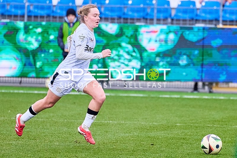 Ein Spieler von Bayer Leverkusen im weißen Trikot läuft mit dem Ball.