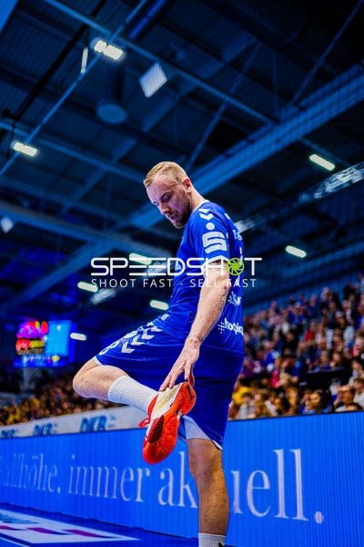 Spieler des VfL Gummersbach dehnt sich am Spielfeldrand.