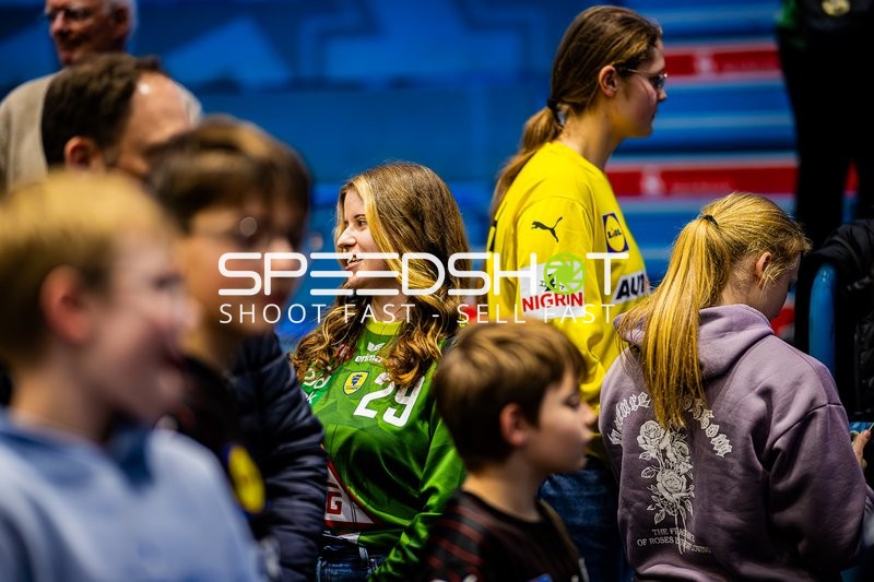 Zuschauer im Gespräch während des Handballspiels.