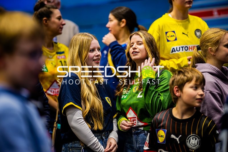 Fans und Zuschauer unterhalten sich in der Halle während des Spiels.