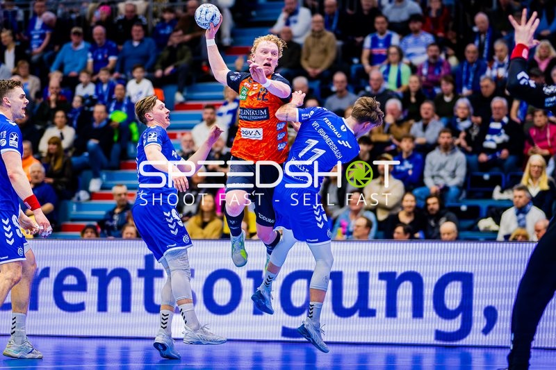 Ein Spieler der Rhein-Neckar Löwen versucht, ein Tor zu werfen, während er von zwei Spielern des VfL Gummersbach verteidigt wird.