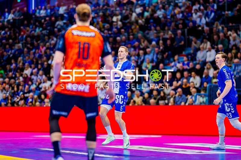 Ein Spieler von Rhein Neckar Löwen in Orange steht einem Spieler von VfL Gummersbach gegenüber.