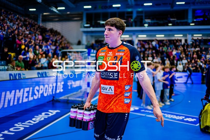 Spieler von Rhein-Neckar Löwen mit Trikotnummer 34 trägt Getränke auf dem Spielfeld