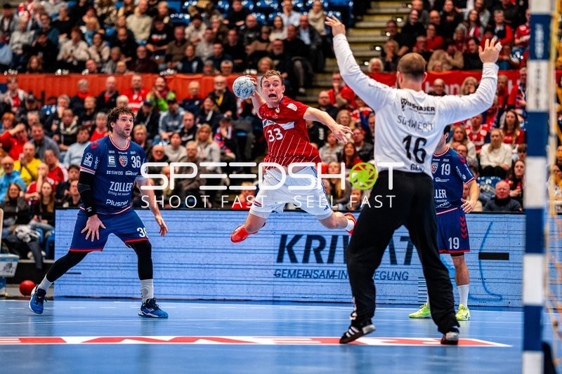 Ein Spieler von HSVH Hamburg springt zum Torwurf, während der Torwart von SG BBM Bietigheim sich darauf vorbereitet, den Ball abzuwehren.