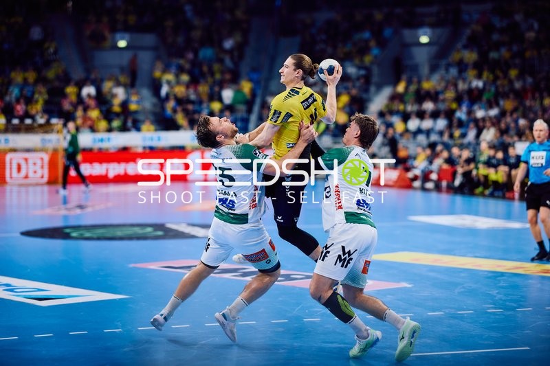 Springender Angriffsspieler wird von zwei gegnerischen Verteidigern blockiert.