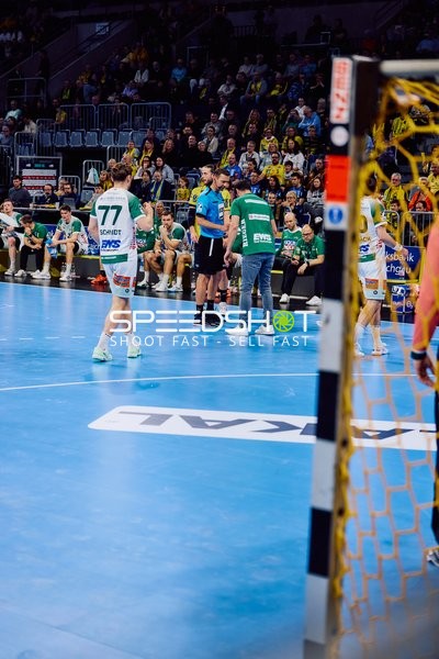 Spielunterbrechung mit Beteiligung eines Spielers von Frisch Auf Göppingen und einem Offiziellen am Spielfeldrand.