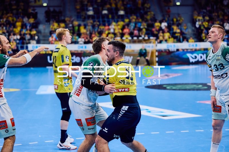 Ein Spieler der Rhein-Neckar Löwen umarmt oder blockiert einen Spieler von Frisch Auf Göppingen.