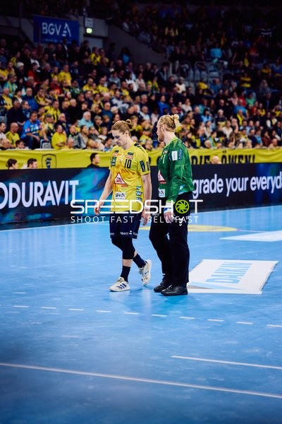 Ein Spieler von Rhein-Neckar Löwen geht mit einem Betreuer vom Spielfeld.