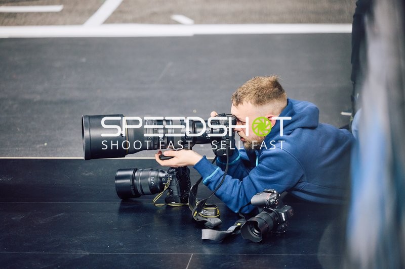 Ein Fotograf liegt auf dem Boden und macht Fotos während des Spiels.