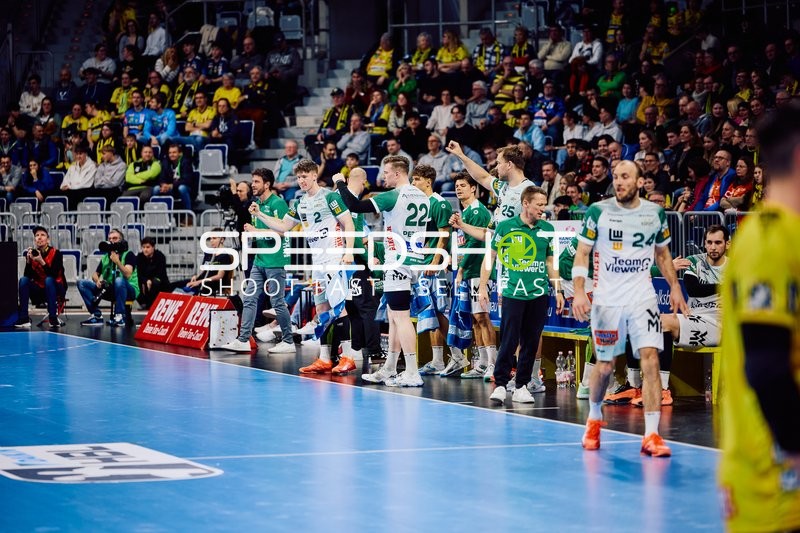 Auswechselspieler von Frisch Auf Göppingen stehen an der Seitenlinie.