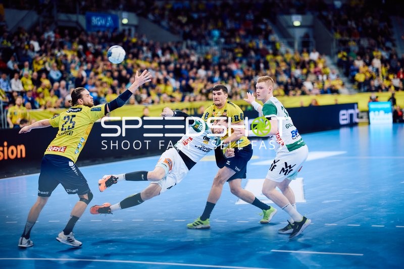 Ein Spieler von Rhein Neckar Löwen versucht, den Ball zu erreichen, während ein Spieler von Frisch Auf Göppingen in der Verteidigung angerempelt wird.