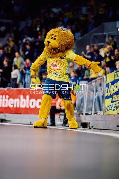 Das Maskottchen der Rhein-Neckar Löwen interagiert mit den Zuschauern am Spielfeldrand.