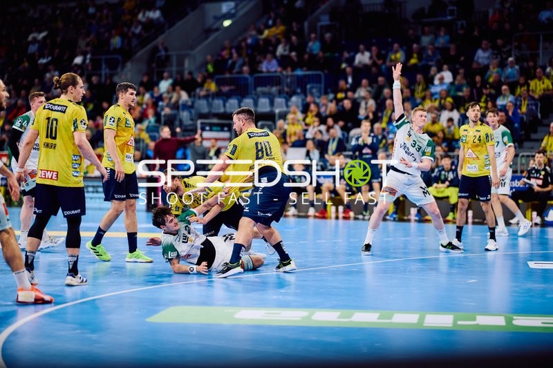 Ein Spieler von 'Frisch Auf Göppingen' am Boden, umgeben von Spielern der 'Rhein-Neckar Löwen'.