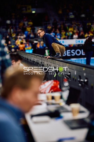 Ein Zuschauer lehnt sich über die Absperrung zur Spielfläche.