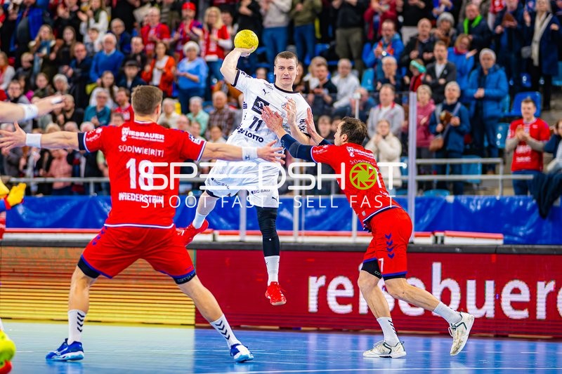 Ein Spieler von THW Kiel springt zum Wurf, während zwei Spieler von SG BBM Bietigheim verteidigen.