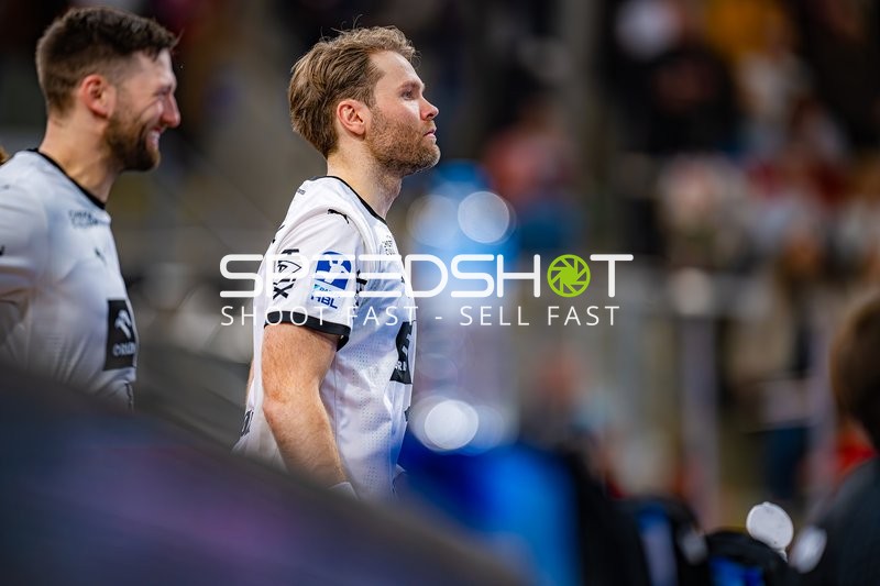 Zwei Spieler von THW Kiel stehen nebeneinander und schauen in eine Richtung.