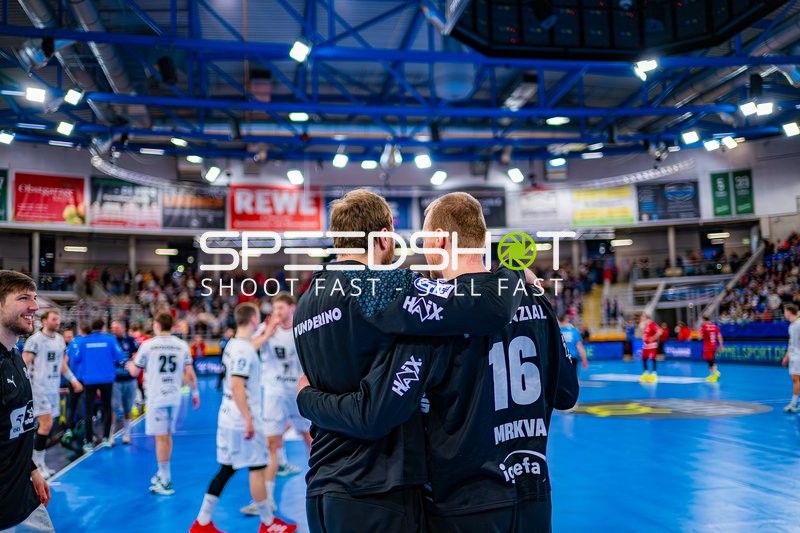 Zwei Spieler von THW Kiel stehen Arm in Arm.