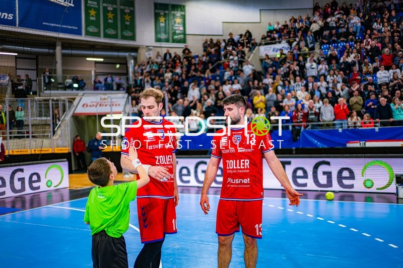 Spieler von SG BBM Bietigheim im Gespräch mit einem jungen Fan auf dem Spielfeld.