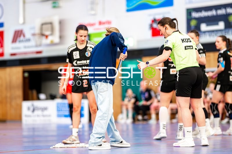 Schiedsrichter bespricht sich mit einem Offiziellen auf dem Spielfeld.