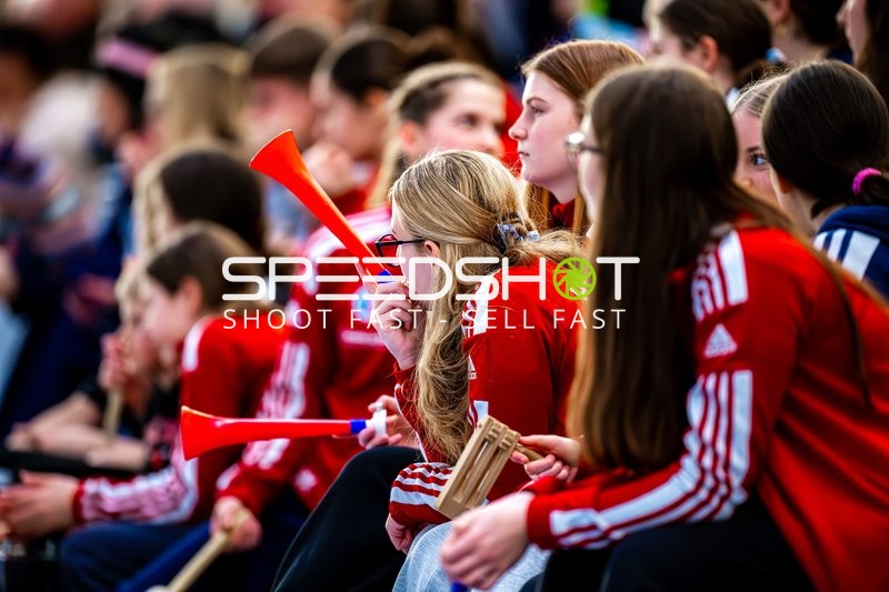 Zuschauer unterstützen ihr Team mit Trompeten und Klatschen.