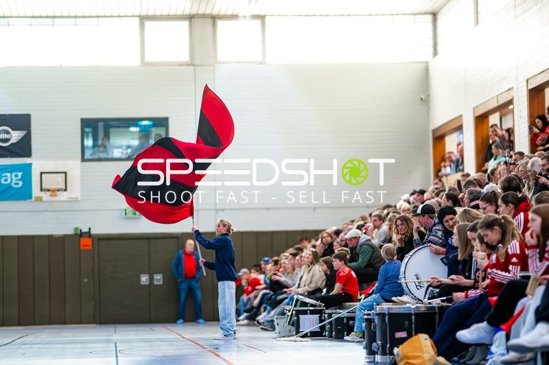 Ein Fan schwenkt eine große rot-schwarze Fahne in der Sporthalle.