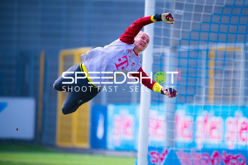 Torhüterin beim Sprung, um einen Schuss zu parieren