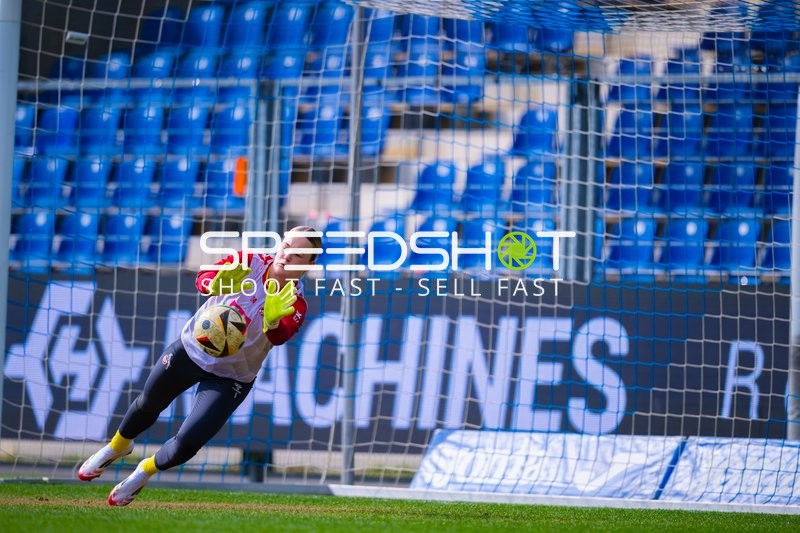 Torwart trainiert das Fangen des Balls während des Aufwärmens