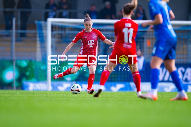 Ein Spieler des 1. FC Köln ist in Ballbesitz und wird von einer Gegenspielerin bedrängt.