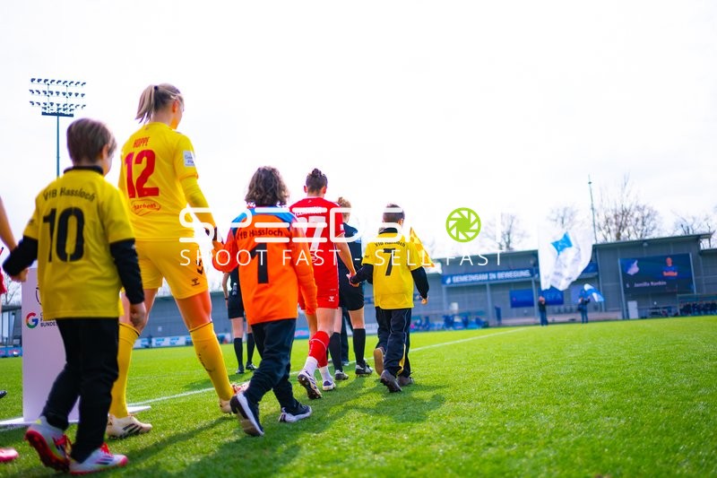 Spielerinnen und Kinder betreten das Spielfeld.