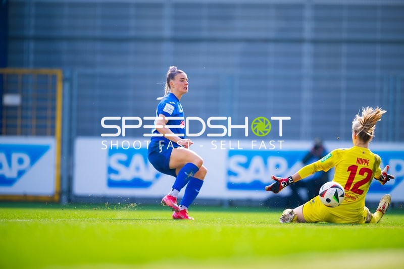 Torhüterin im gelben Trikot rutscht und versucht, den Ball zu klären.