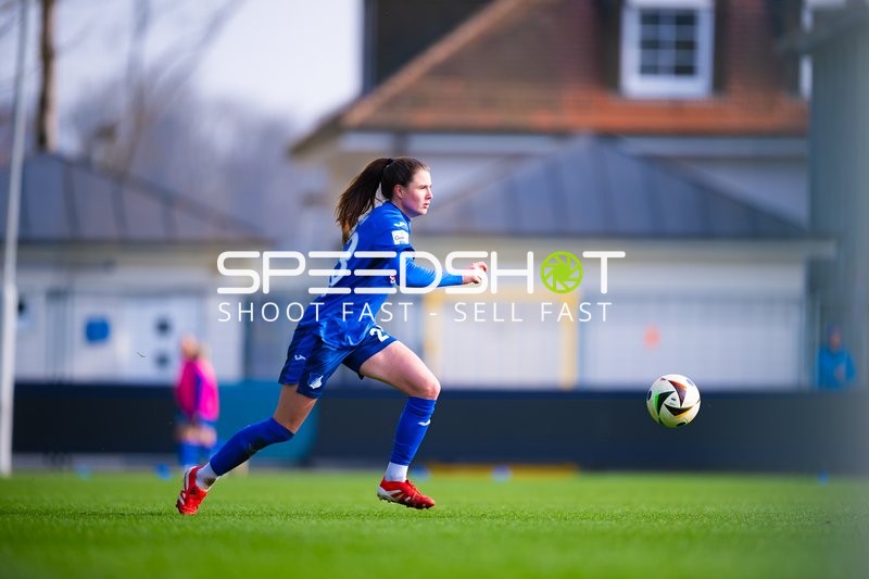 Der Spieler in blau sprintet mit dem Ball am Fuß über das Spielfeld.