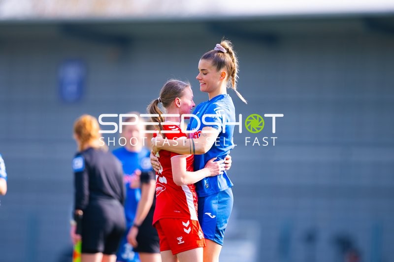 Zwei Spielerinnen umarmen sich herzlich auf dem Spielfeld.