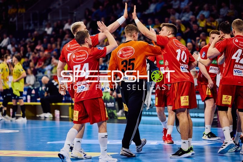 Spieler von TSV Hannover Burgdorf geben sich High-Fives.