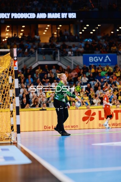 Der Torwart der Rhein-Neckar Löwen steht bereit, während ein Spieler von TSV Hannover-Burgdorf im Hintergrund zu sehen ist.