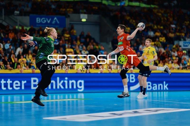 Ein Spieler von Rhein Neckar Löwen wirft auf das Tor, während der Torwart in grün versucht, den Ball zu parieren.