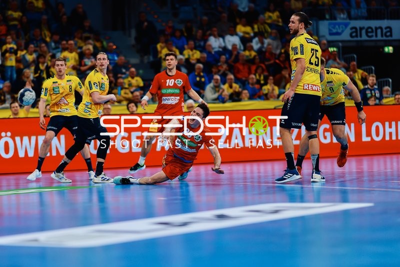 Ein Spieler vom TSV Hannover Burgdorf rutscht oder fällt während einer hektischen Spielsituation, während zwei Spieler von Rhein Neckar Löwen dabei sind.