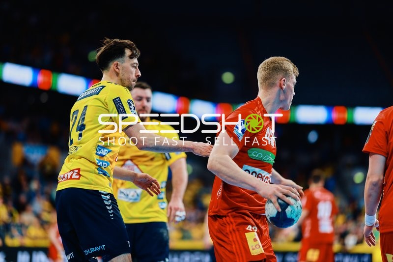 Ein Spieler der Rhein-Neckar Löwen versucht einen Gegner von TSV Hannover Burgdorf zu blockieren.