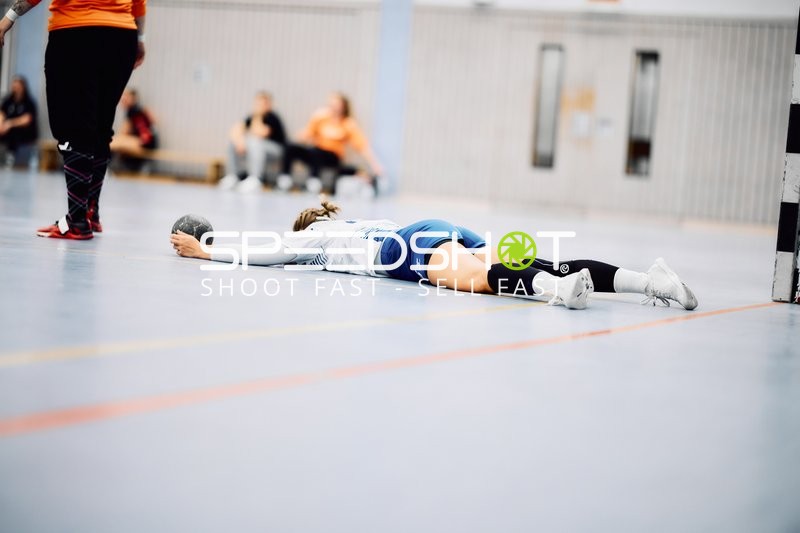 Spielerin liegt auf dem Boden mit einem Ball in der Hand