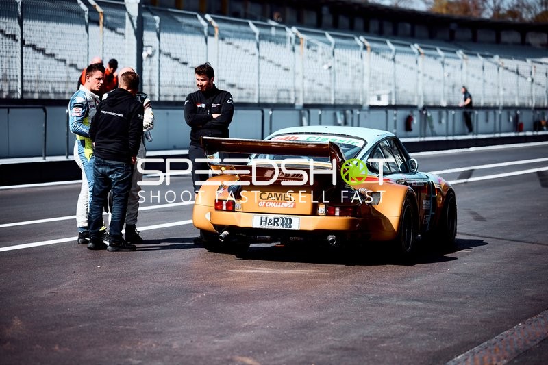 Gespräch in der Boxengasse neben einem Porsche