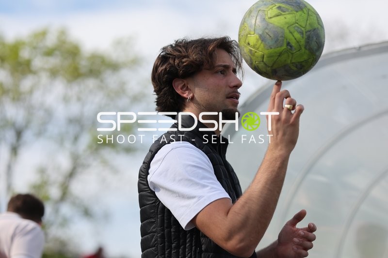 Jonglieren mit grünem Ball am Spielfeldrand