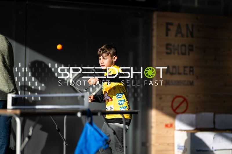 Kind spielt Tischtennis vor dem Fan Shop