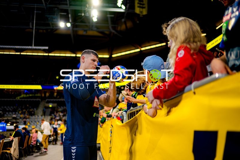 Spieler signiert Handball für junge Fans