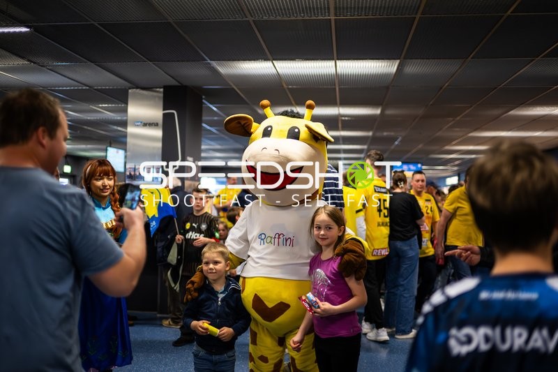 Fans posieren mit Maskottchen