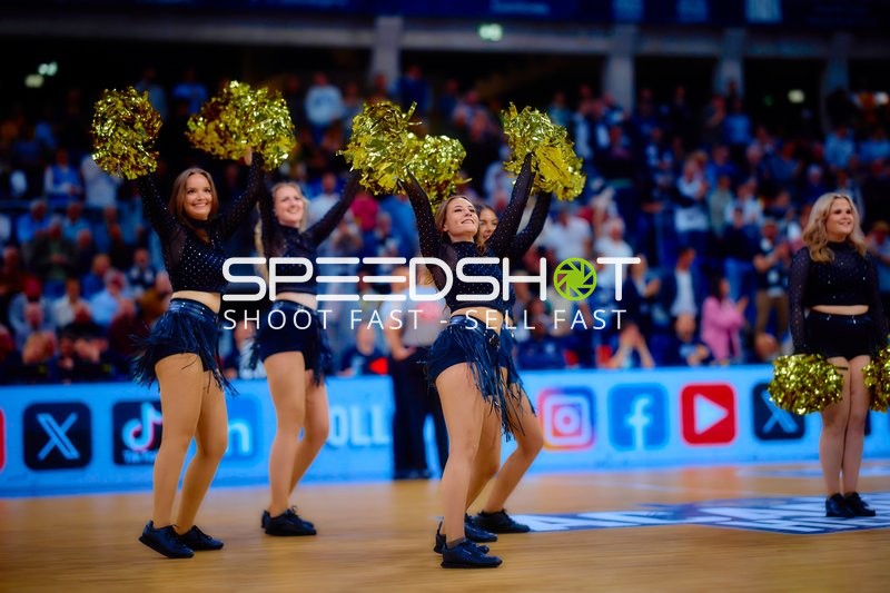 Cheerleader mit goldenen Pompons tanzen auf dem Spielfeld