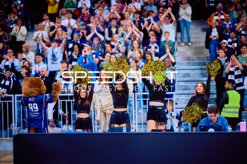 Maskottchen und Cheerleader jubeln vor Publikum