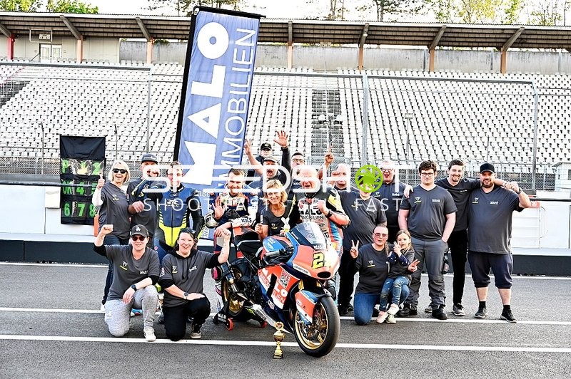 Gruppe mit Motorrad und Pokal